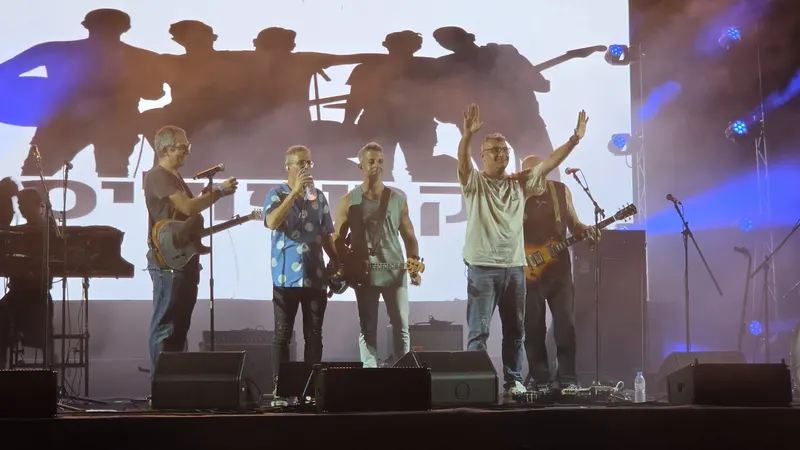 חברי להקת אקרופוליס על הבמה בהופעה חיה, באור כחול עם עשן במה